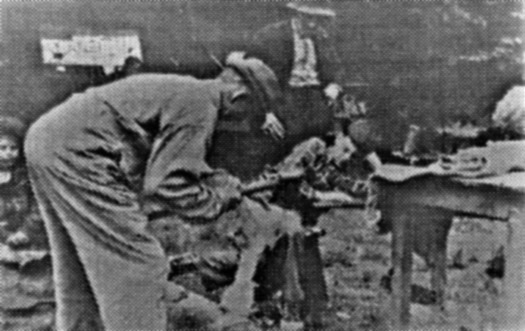 Old-Timer John Edwards and Gene Gold carving spoons with an adze, Camp Woodland, 1954.